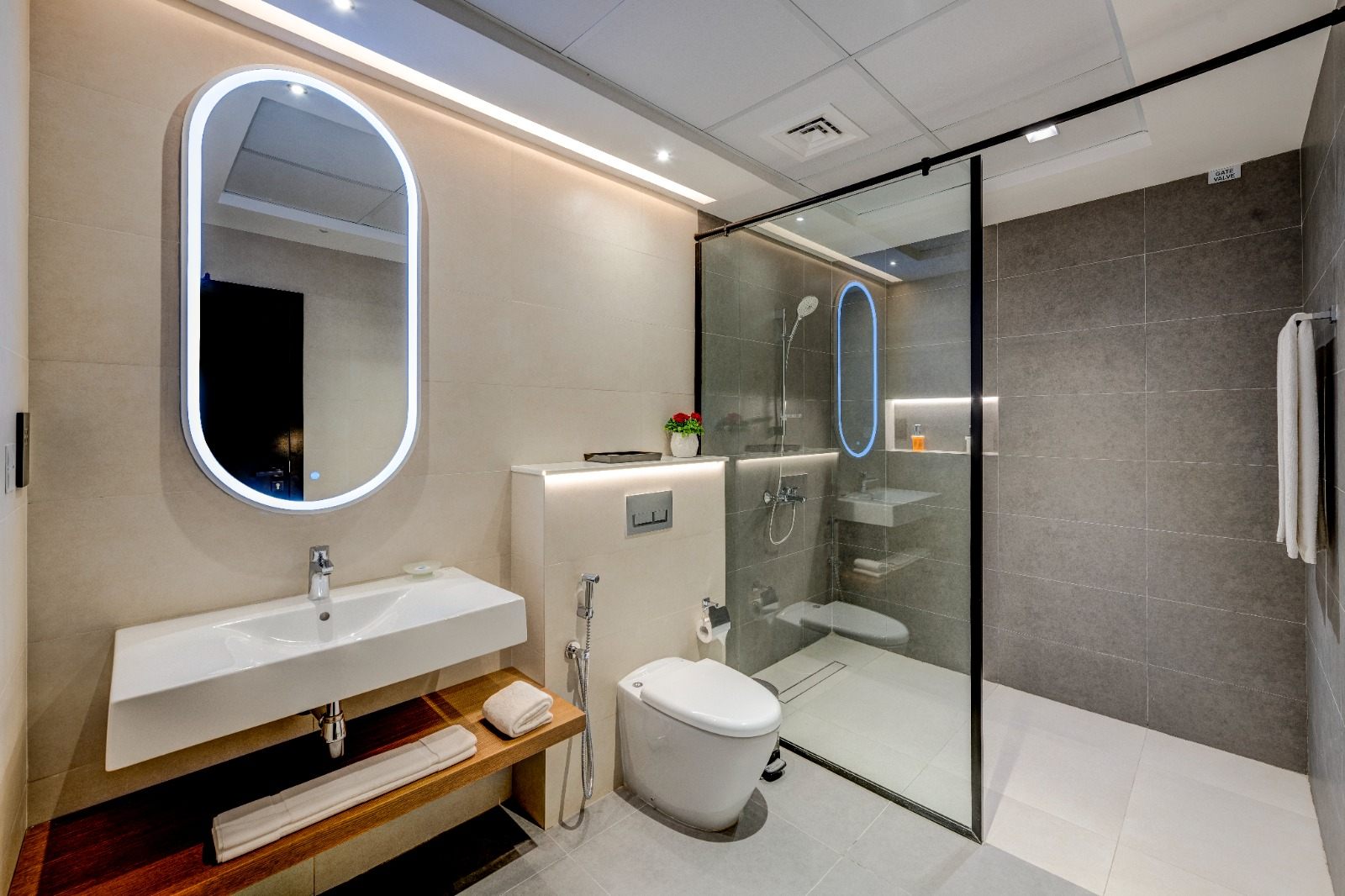 Bathroom with backlit oval mirror and walk-in shower