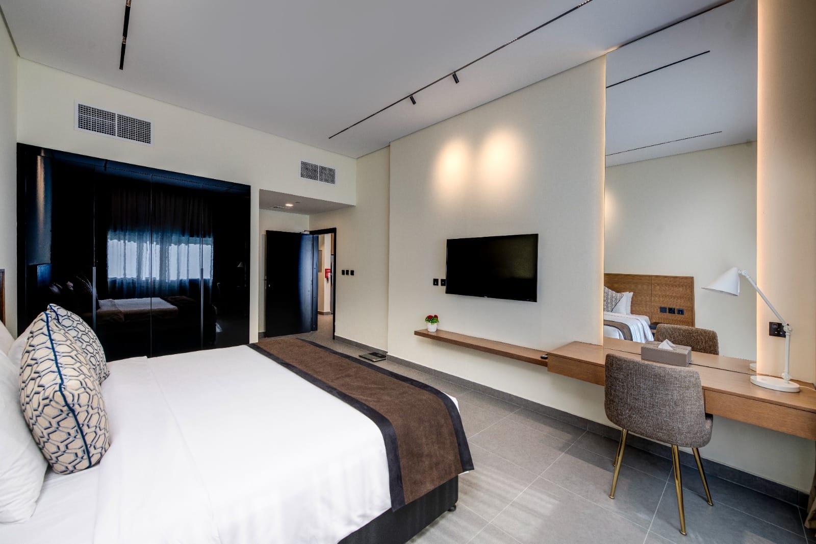 Spacious bedroom with large mirrored wardrobe in a larger residence