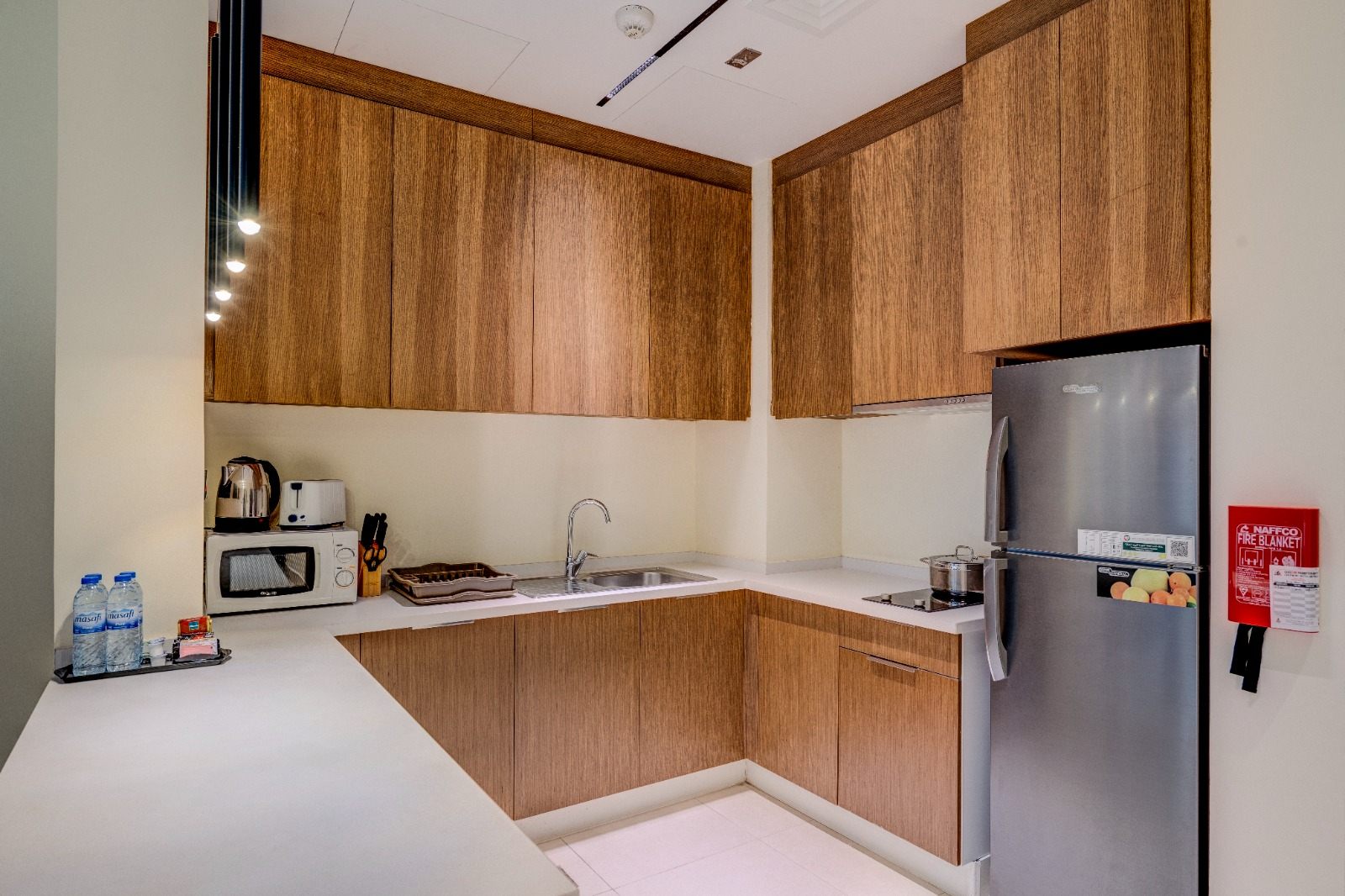 Full kitchen with L-shaped timber cabinetry and appliances