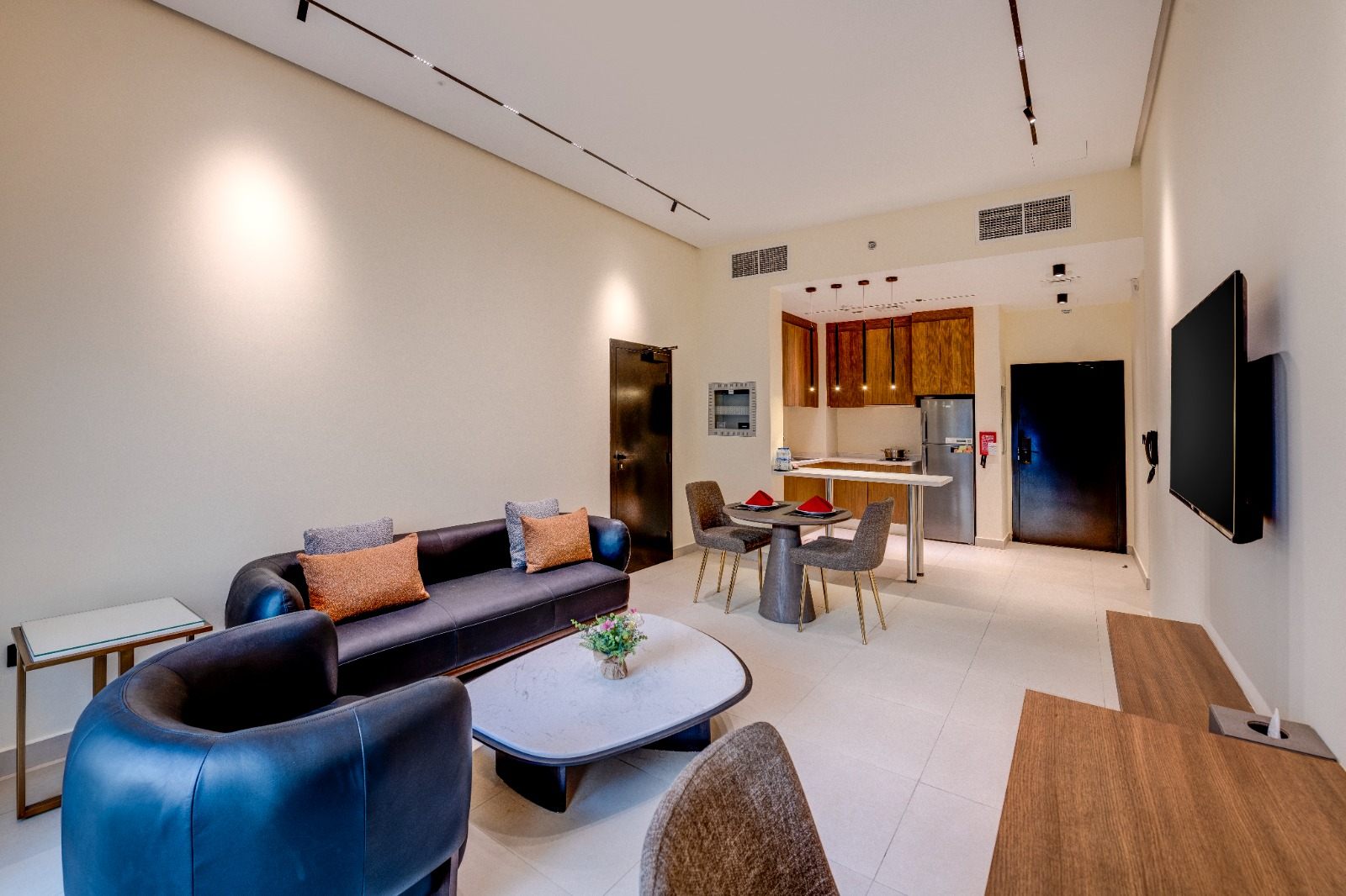 Two-bedroom residence lounge with sofa, lounge chairs and dining set